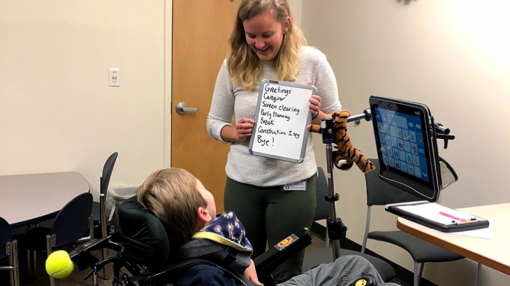 Audiologist assists with AAC device